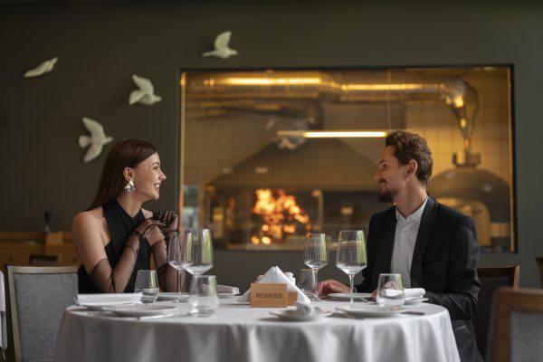 A couple enjoying a romantic dinner at a high-end restaurant.