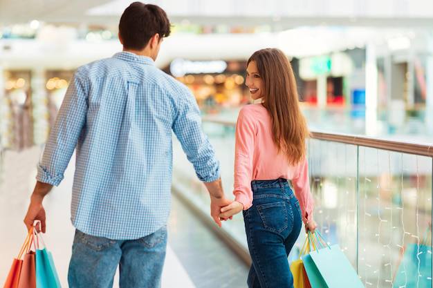 A couple walking hand-in-hand through a luxury shopping district.