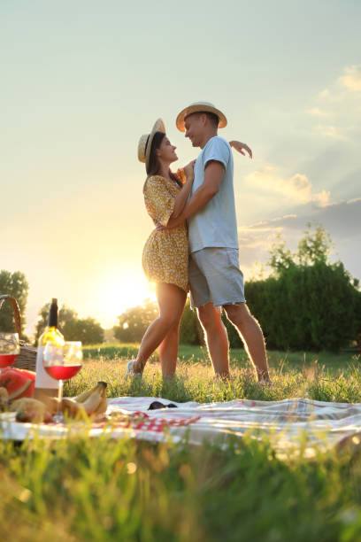 Happy couple in their 30s enjoying a date in a park.